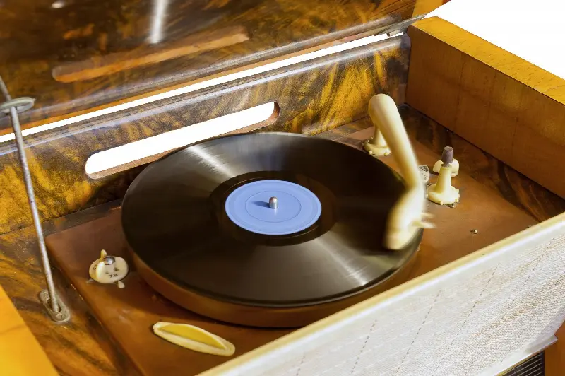 Disque vinyle qui tourne sur un ancien tourne-disque en bois
