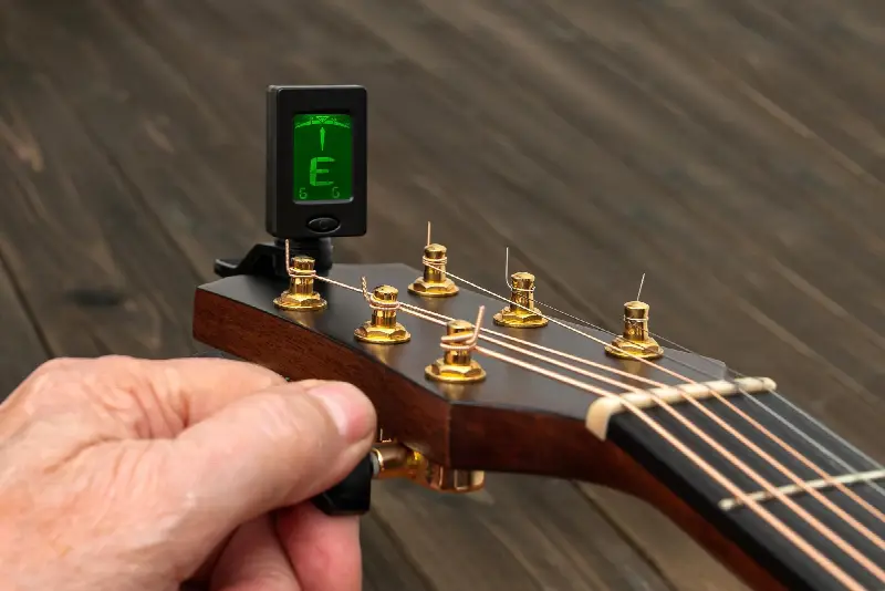 Accordeur électronique pincé sur la tête d'une guitare