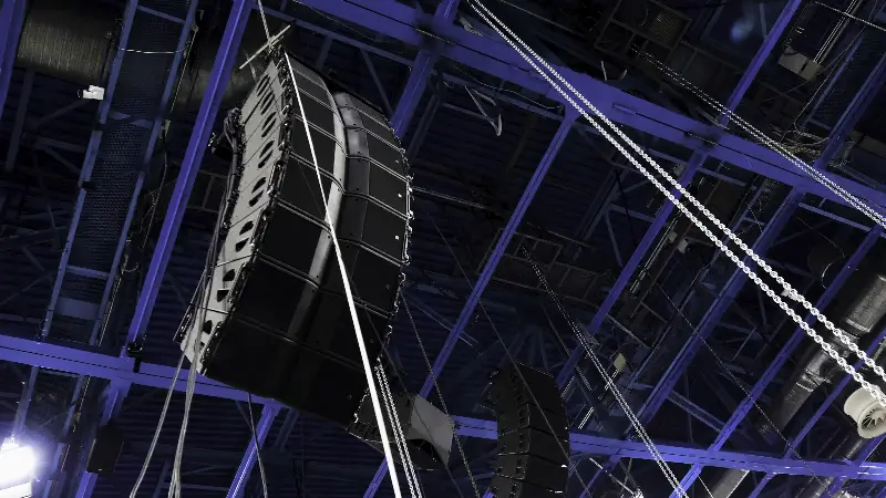 Enceintes line array suspendues à la charpente métallique d'une grande salle de concert