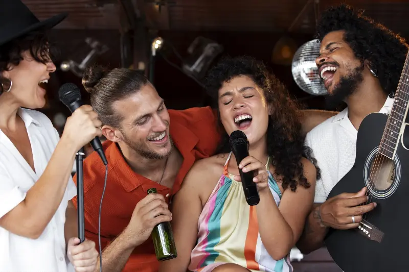 Un groupe d'amis chante ensemble dans deux micros, tard le soir