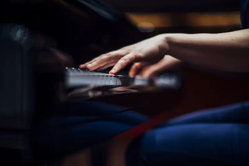 Mains d'un pianiste en mouvement rapide sur le clavier d'un piano à queue