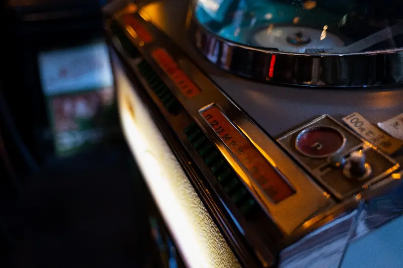 Panneau de sélection éclairé d'un juke-box ancien, un disque visible sous la vitre