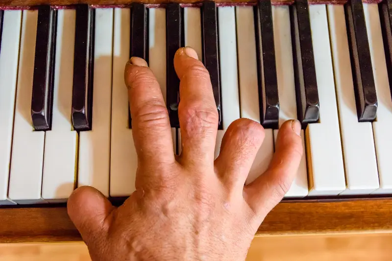 Main d'un pianiste posée sur le clavier, vue de dessus