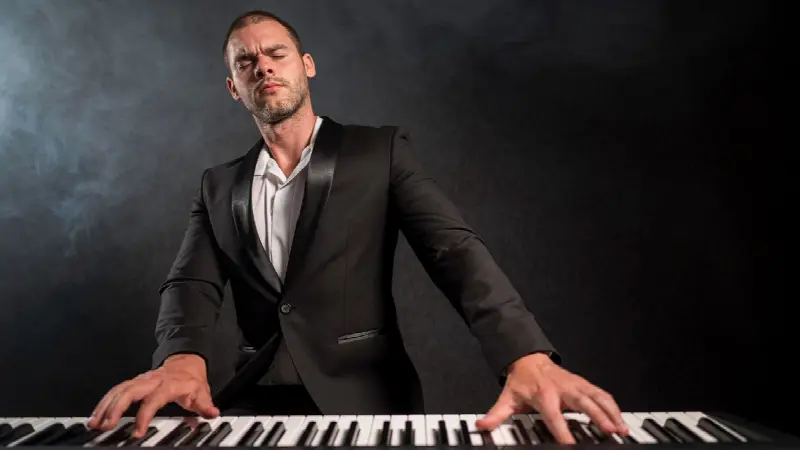 Pianiste en costume noir, les yeux fermés, jouant sur un clavier dans la fumée