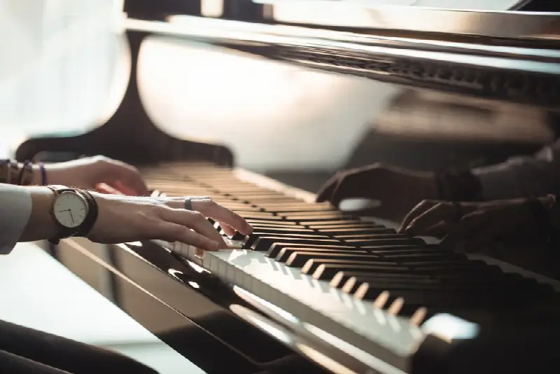 Mains posées sur le clavier d'un piano à queue