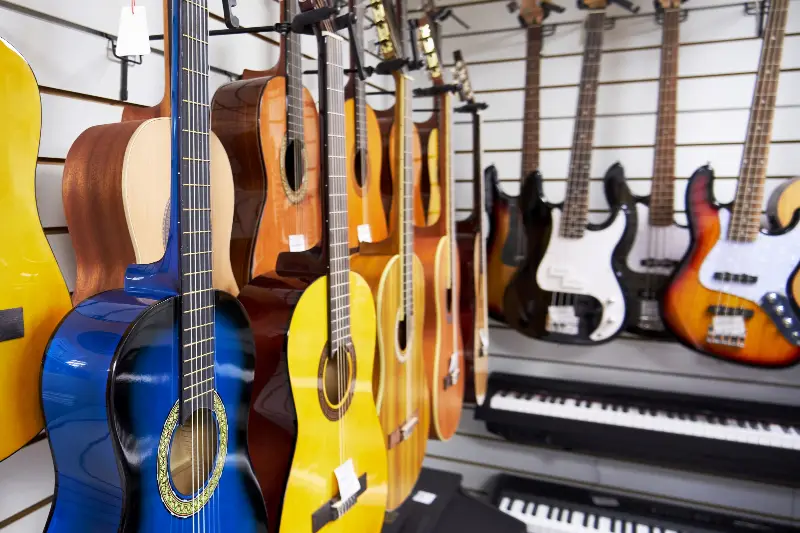 Rayon d'un magasin de musique : guitares classiques, basses électriques et claviers