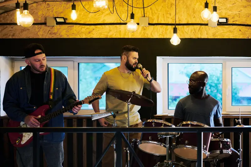 Trois musiciens, guitare électrique, chant et batterie, jouant dans un petit bar