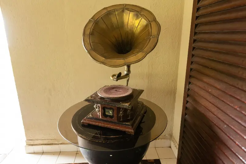 Gramophone ancien à pavillon de cuivre posé sur un guéridon